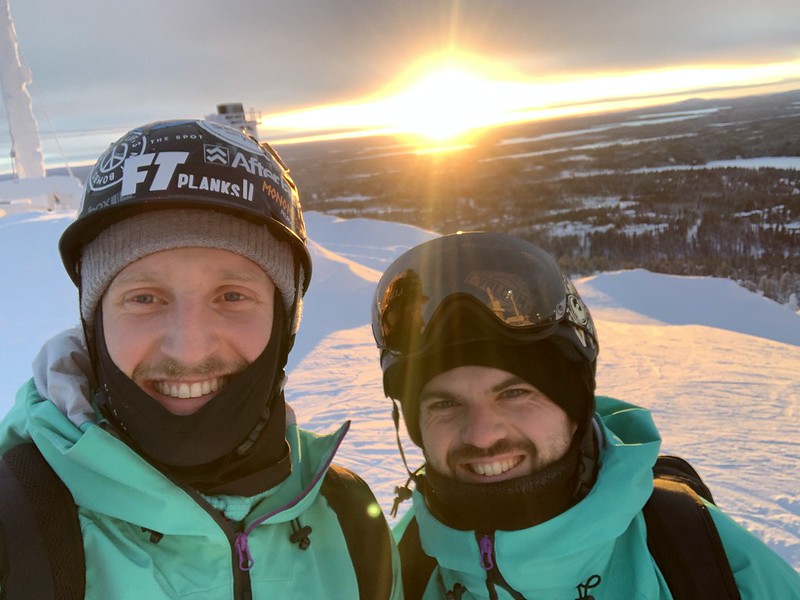 Two Crystal staff in Ski Uniform on a mountain with a sunset in the background